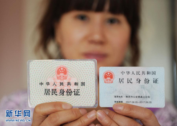 12月23日,一名上海市民展示两代居民身份证